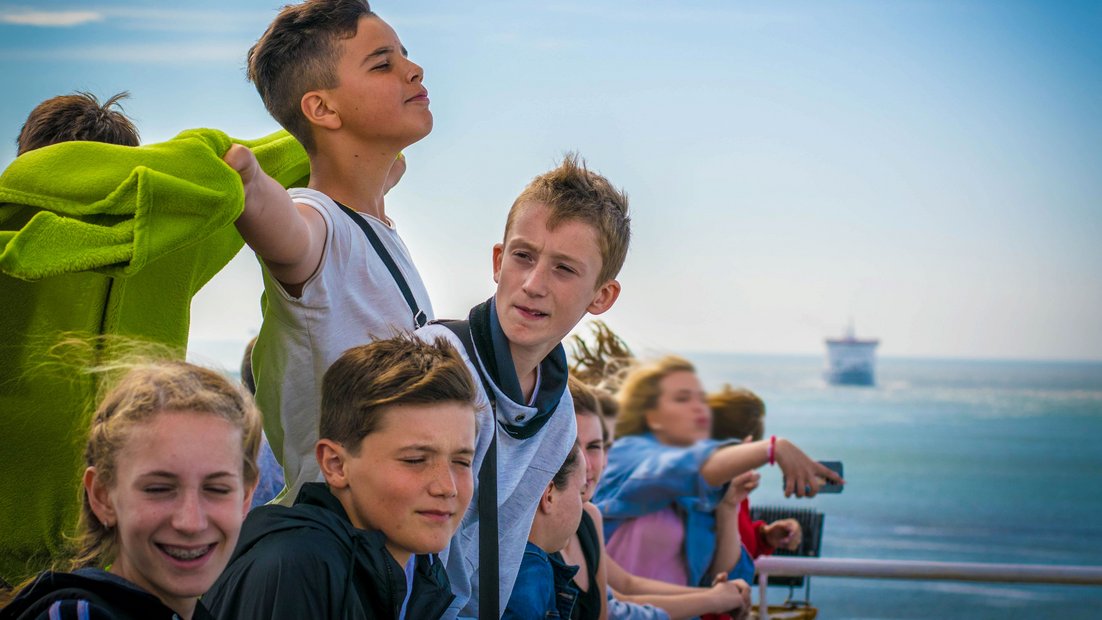 I giovani sul ponte di una nave godono della vista.