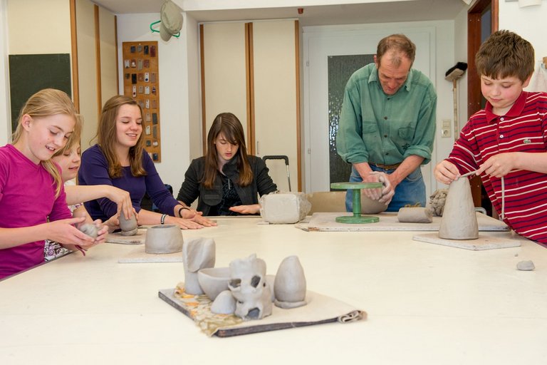 Gli studenti fanno ceramiche insieme al loro insegnante.
