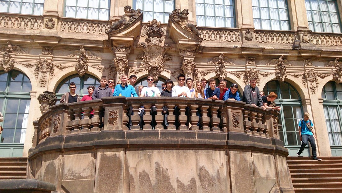 Un gruppo di studenti si trova su un balcone di un edificio storico.