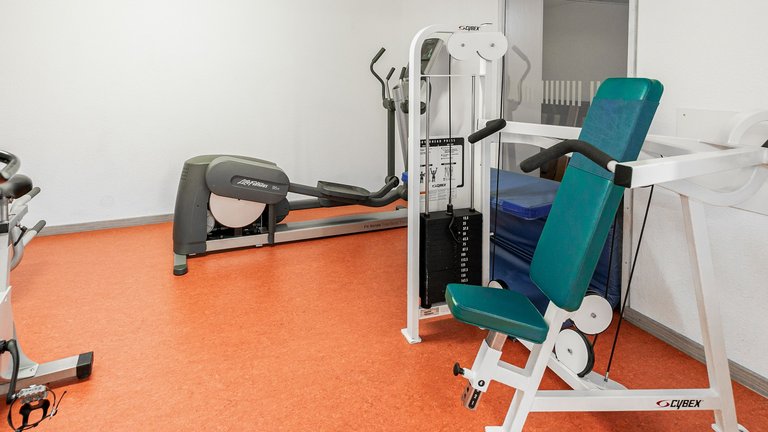 Sala fitness con panca pesi e ellittica