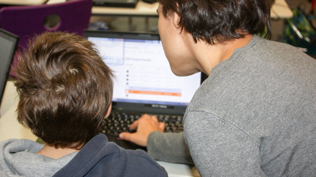 Due studenti alla ricerca di contenuti multimediali sul proprio laptop